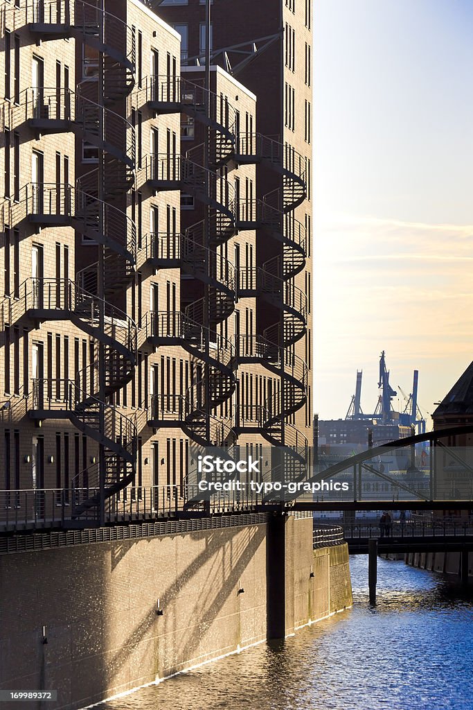 Historical Warehouse District, Speicherstadt, Hamburg Historical Warehouse District, Speicherstadt, Hamburg in the evening with harbour in the background. A very famous large landmark in Hamburg is the warehouse district Speicherstadt. The red brick houses were built original from 1883 to 1927. Architecture Stock Photo