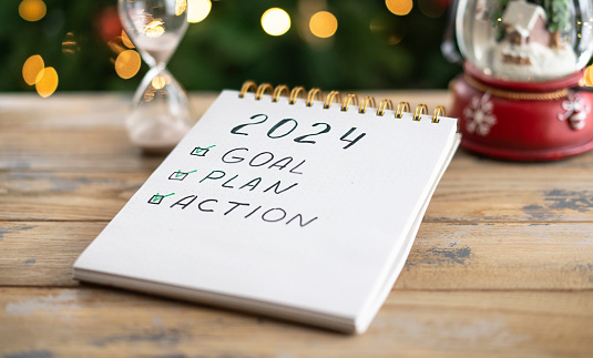 Notepad with plans for the next year and the inscription - 2024 goal, plan, action