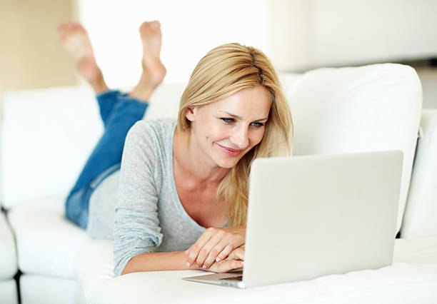 istock Smiling woman working on laptop at home 169989922
