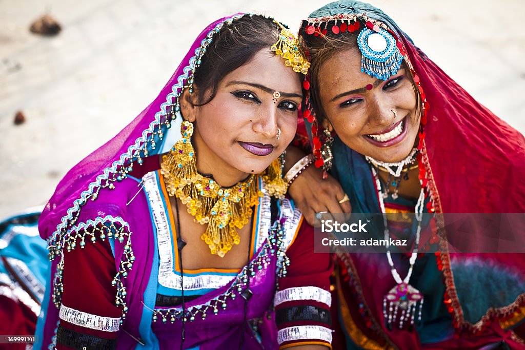 Indian Girls Smiling in Rajasthan Desert Portrait of two Indian girls dressed in Rajasthani attire, laughing candidly Bollywood Stock Photo