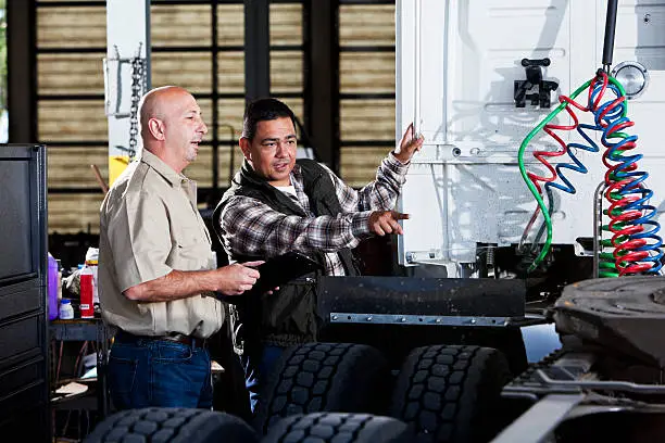 Photo of Men in garage with semi-truck