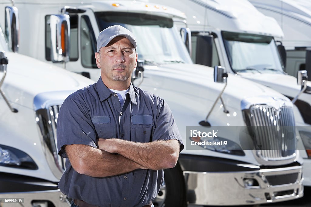 Conductor de camión de pie frente a grandes bancos - Foto de stock de Camionero libre de derechos