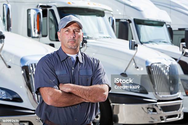 Conductor De Camión De Pie Frente A Grandes Bancos Foto de stock y más banco de imágenes de Camionero - Camionero, Camión de peso pesado, Camión articulado