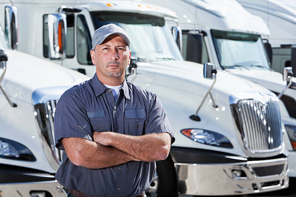 istock Truck driver standing in front of big rigs 169992414