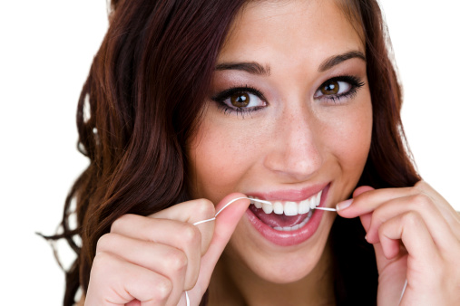 Headshot of a cute girl flossing her perfect teeth 
