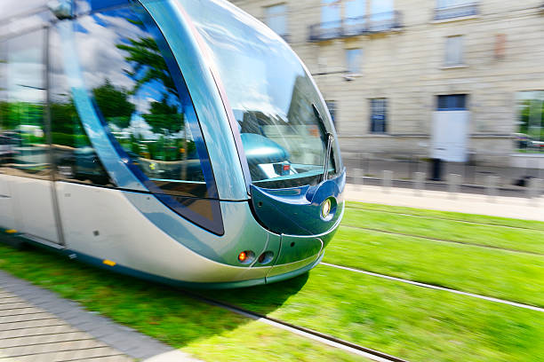Tram, panning, on grass Environment friendly tram on grass, motion blurred background by panning. blurred motion street car green stock pictures, royalty-free photos & images
