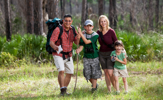 Hispanic family having fun, hiking in woods.