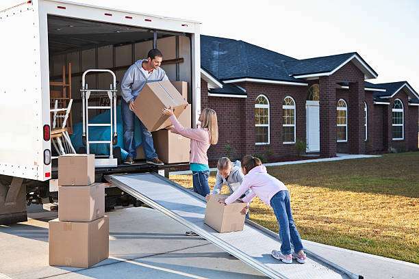 Family moving house, unloading truck Moving house. Family loading or unloading moving van. moving van stock pictures, royalty-free photos & images