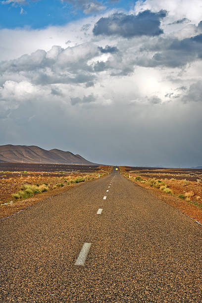 rocky road nel deserto dell'erg chebbi marocco africa - mini van ecosystem dramatic sky meteorology foto e immagini stock