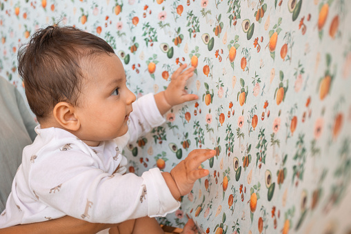 Baby curiously touching colorful paper