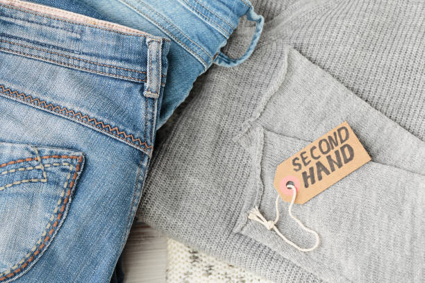 istock Stack of blue jeans and tag with inscription second hand 1699943070
