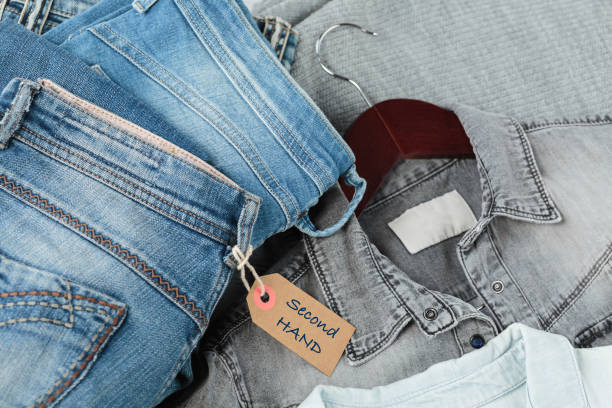 istock Stack of blue jeans and tag with inscription second hand 1699943076