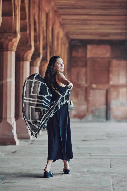 donna dell'asia orientale in vestito nero che danza con sciarpa traslucida tra le colonne del tempio antico - taj mahal mahal door temple foto e immagini stock