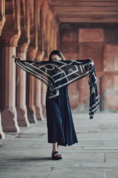 east asian woman in black dress dancing with translucent scarf among columns of ancient temple - taj mahal mahal door temple imagens e fotografias de stock