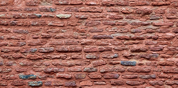 Ancient red brick wall of old house exterior, red brick texture on brickwork masonry with bricklayer, aged old red brick building construction, design background