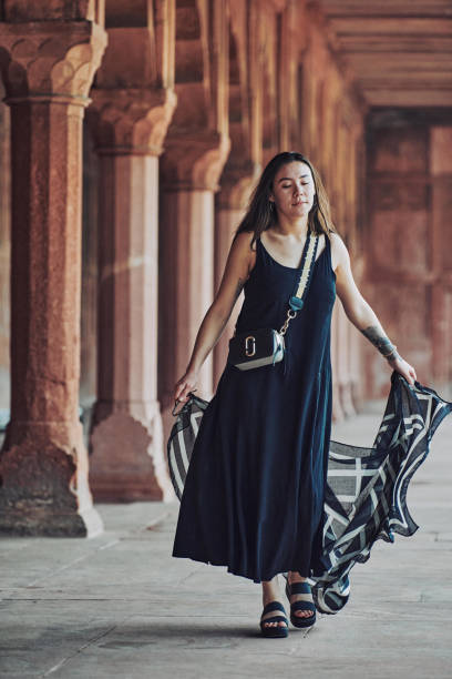 восточноазиатская женщина в черном платье танцует с полупрозрачным шарфом среди колонн древнего храма - taj mahal mahal door temple стоковые фото и изображения