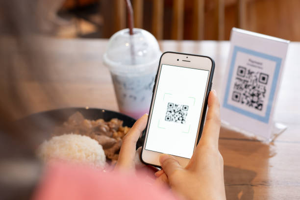 istock Woman use smartphone to scan QR code for order menu in cafe restaurant with a digital delivery. Choose menu and order accumulate discount. E wallet, technology, pay online, credit card, bank app 1699959554