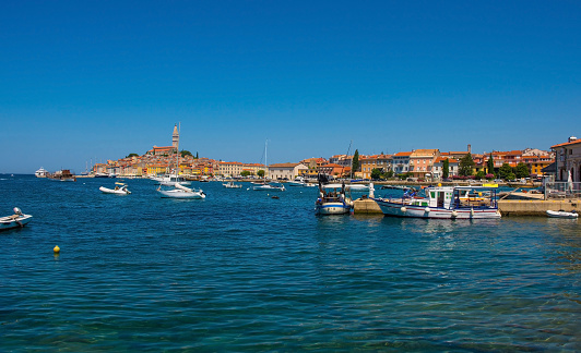 Boats on the historic waterfront of the medieval coastal town of Rovinj in Istria, Croatia. Saint Euphemia Church is central left