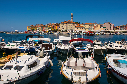 Boats on the historic waterfront of the medieval coastal town of Rovinj in Istria, Croatia. Saint Euphemia Church is centre