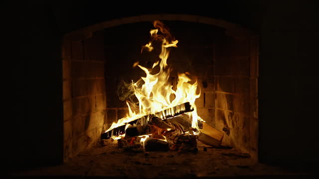 Burning Fire In The Fireplace. Slow motion. A looping clip of a fireplace with medium size flames. Cozy Relaxing Fireplace.