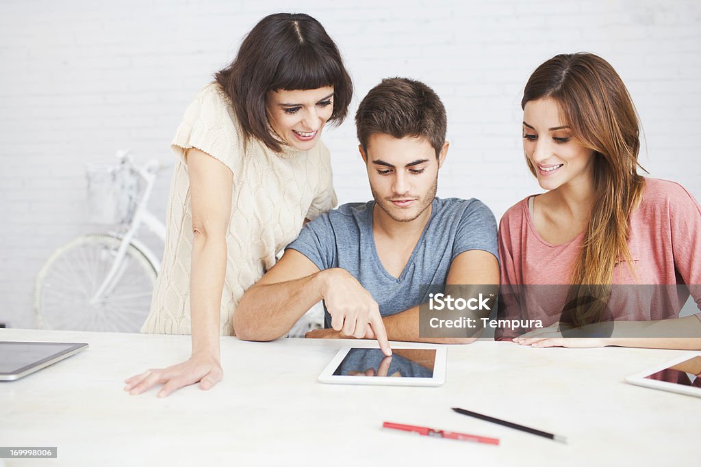Tres personas con una tableta digital en su descanso, trabajo - Foto de stock de 20-24 años libre de derechos