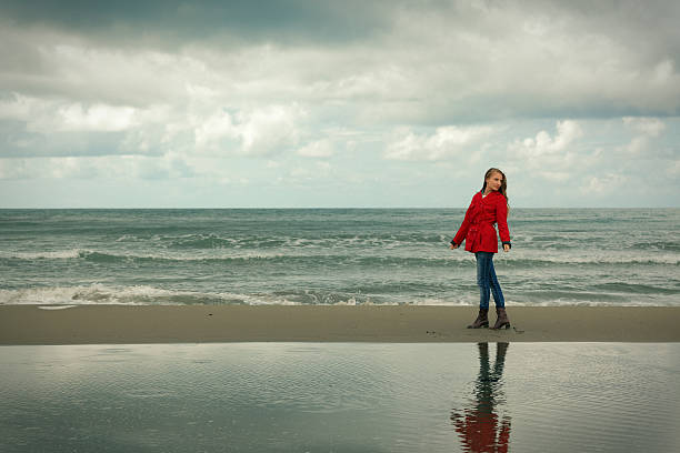 istock lonely girl walking at the sea 169999014
