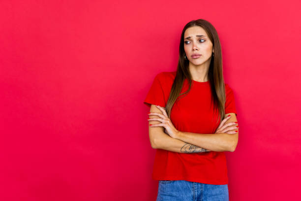 istock Beautiful young woman standing over red isolated background 1699993974