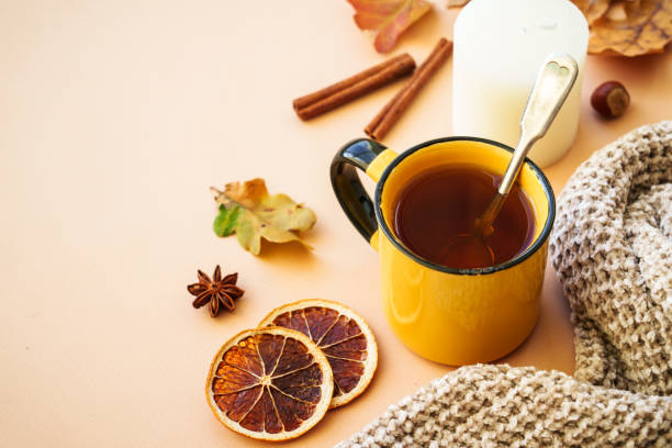 istock Autumn tea, spices, orange leaves, and home decor. 1699995874