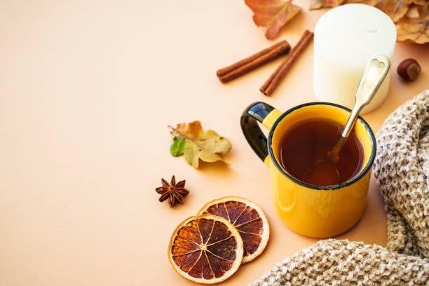 istock Autumn tea, spices, orange leaves, and home decor. 1699995876