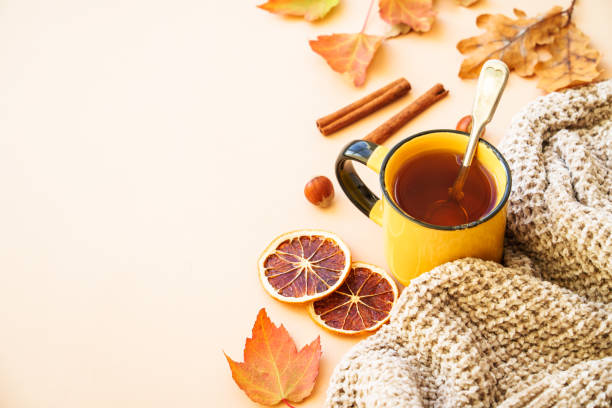 istock Autumn tea, spices, orange leaves, and home decor. 1699996423