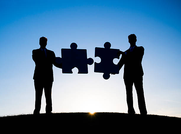 istock Two Businessmen holding the jigsaw puzzle 170000344