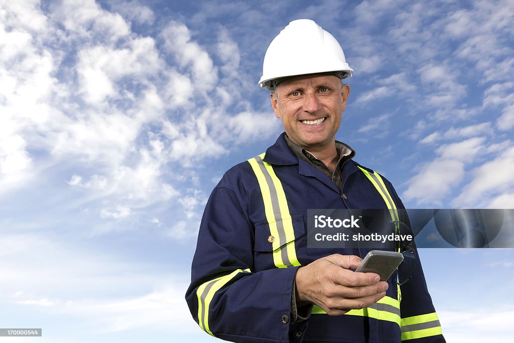 Trabajador usando un teléfono inteligente - Foto de stock de Contratista de obras libre de derechos