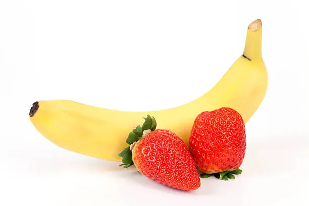 Banana and two Strawberries on white background.