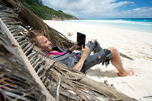 náufrago hombre descansa en la playa con tableta - digital tablet robinson crusoe castaway stranded fotografías e imágenes de stock