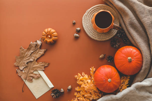 istock Autumn background top view, pumpkin and leaves on orange background 1700011343