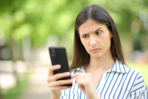 istock Woman reading suspicious message on phone 1700012470