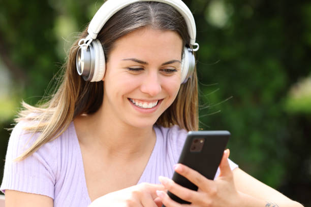 istock Happy teen using cell phone and headphone 1700015437