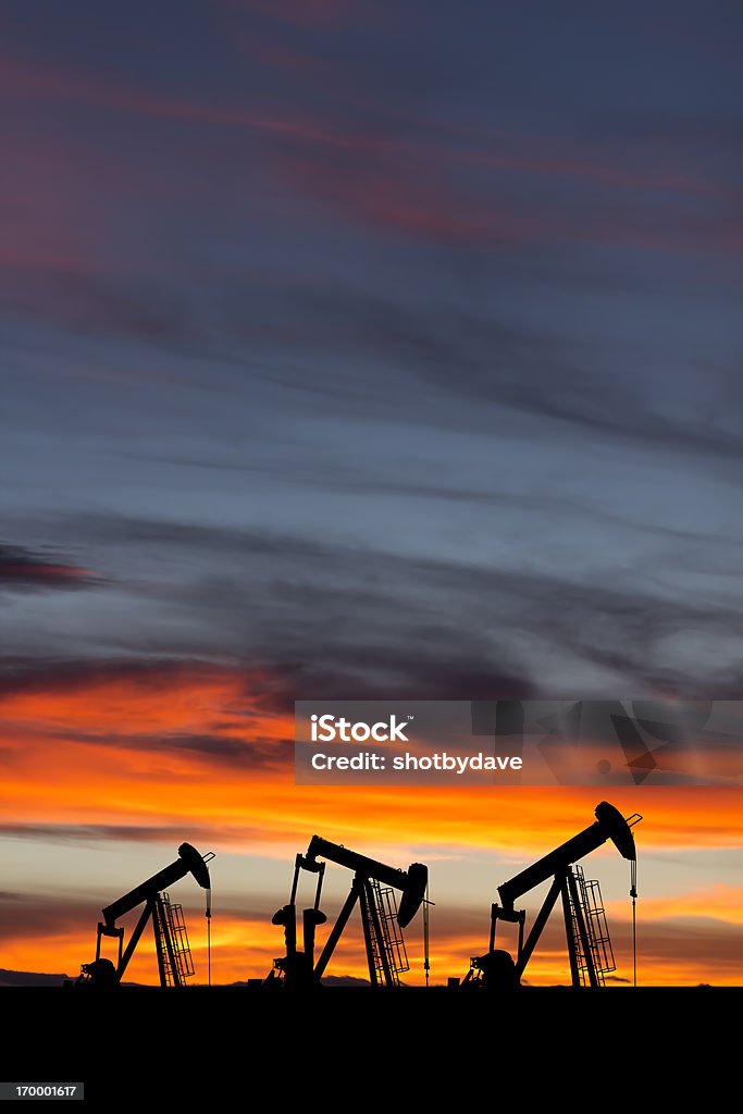 Pompe dell'olio al tramonto - Foto stock royalty-free di Petrolio