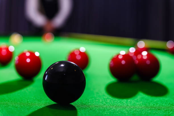 istock Snooker black one ball and snooker player with competitor blur while aiming black ball on snooker table in background. 1700019618