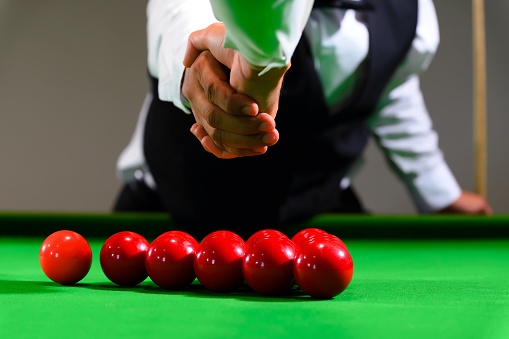 Snooker competitors shake hands before starting their game.