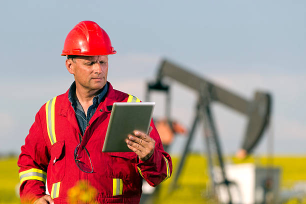 нефтяник и доступ в интернет - oil industry digital tablet manual worker mining стоковые фото и изображения