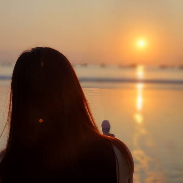 istock Woman eating ice cream with sunset view 1700020814
