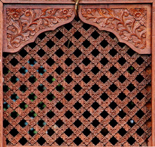 Traditional Wooden Window textured background, Wood Carved Wall or Ceiling Panel, pattern photography. Wooden window carved details on a Hindu temple. Ancient window texture.