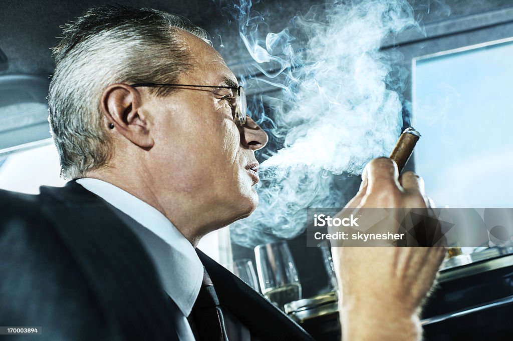 Adulto maduro hombre de negocios para fumadores de un habano en limusina. - Foto de stock de Hombres libre de derechos