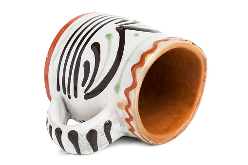 Craft ceramic painted mug lying on white background