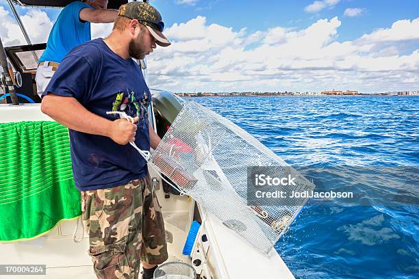 Fisherman Throwing A Crab Trap Stock Photo - Download Image Now - Crabbing, Nautical Vessel, Men