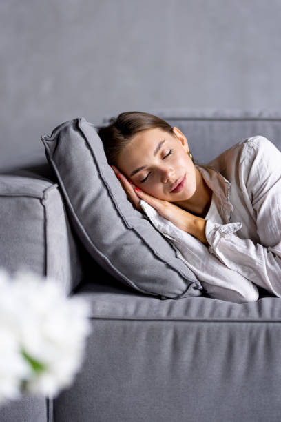 istock Relaxed cheerful woman resting on soft comfortable big sofa dreaming, relaxing 1700046761