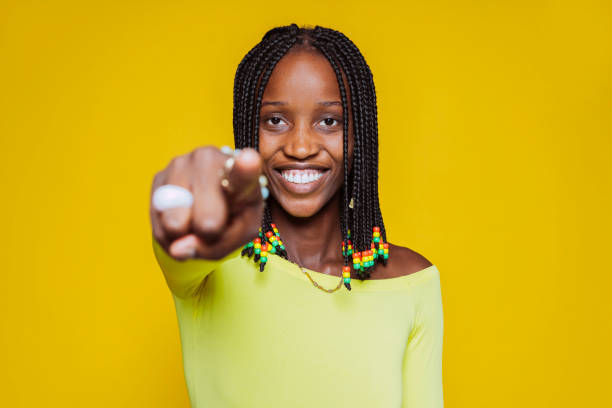 istock African woman points finger at camera over yellow wall 1700055081