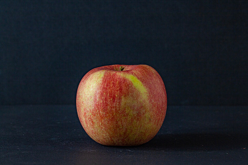 A red apple in autumn on the black background.