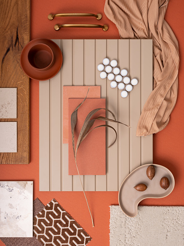 Modern flat lay composition in orange and beige color palette with textile and paint samples, lamella panels and tiles. Architect and interior designer moodboard. Top view. Copy space.